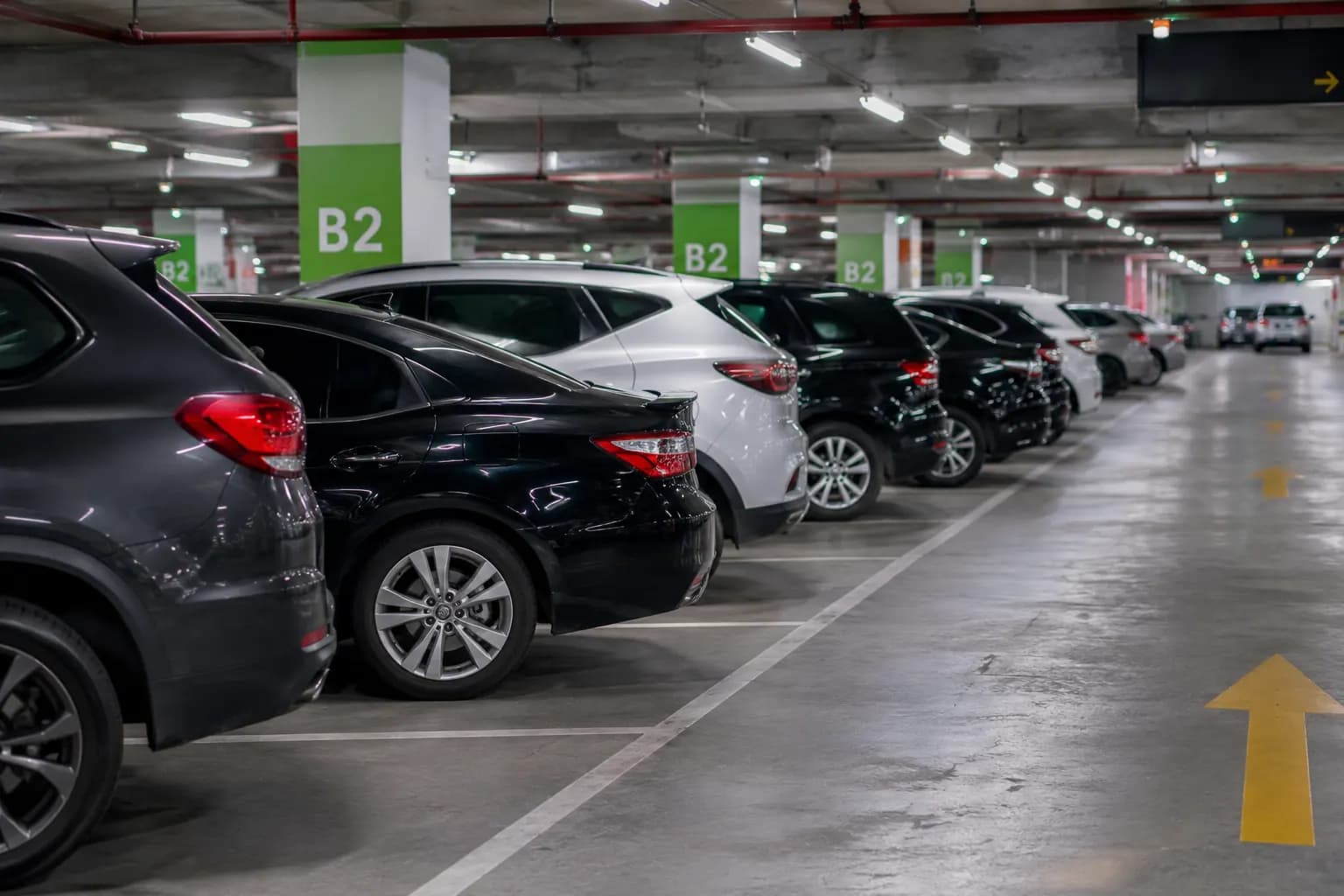 Luxury vehicles parked in a modern airport parking facility